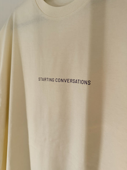 Beige sweatshirt with 'STARTING CONVERSATIONS' text on the front.